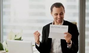 man holding iowa payroll paystub